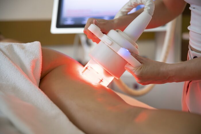 Cabezal de luz LED sobre el brazo de una clienta, en cabina