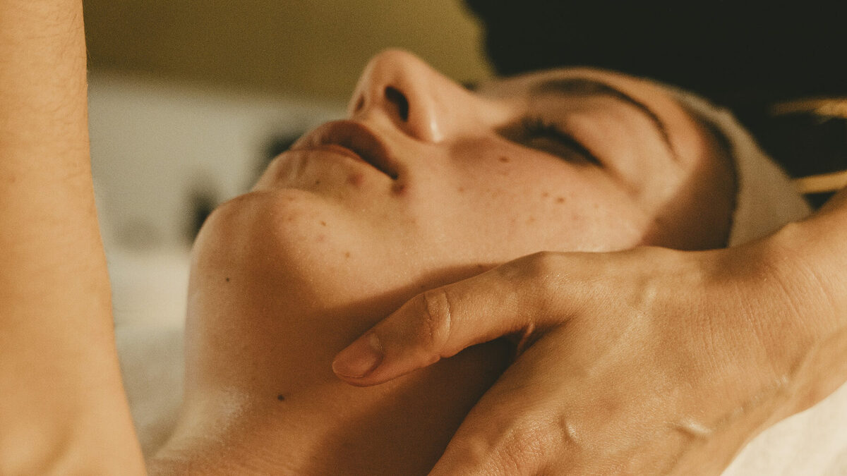 Masaje facial en la cabina de Bless, con luz cálida